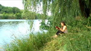 stock-footage-girl-reads-the-book-on-the-bank-of-river (1)